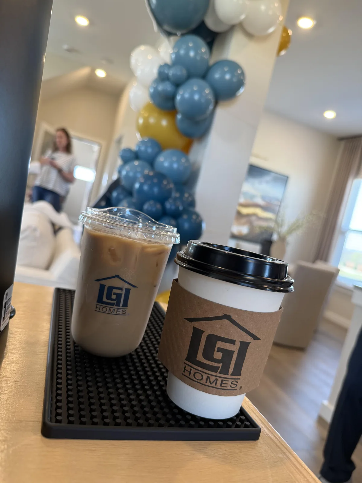 Iced and hot coffee in custom LGI Homes-branded cups and sleeves at a corporate event catered by Enlightened Café in DFW